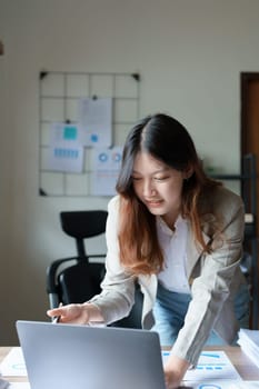 financial, Planning, Marketing and Accounting, portrait of Asian employee checking financial statements using documents and computer laptop at work.