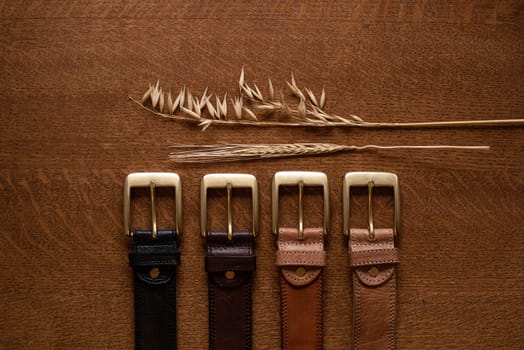Leather belts set on a wooden table. natural lighting.