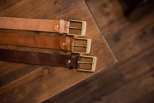 Leather belts set on a wooden table. natural lighting.