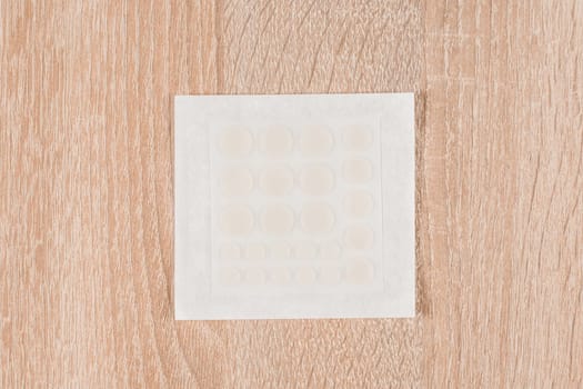 Set of round acne patches on wooden background. Close-up acne patch facial rejuvenation. Facial cleansing cosmetology