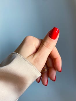 Beautiful nails manicure photo. Red color top nail polish. Female hand, rings, closeup photo, aesthetics. Manicure design, square nail shape. Luxury style, Creative beauty photo, Woman hand. High quality photo