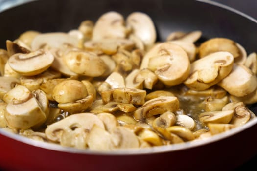 Mushrooms being fried in a frying pan, the process of cooking food. Concept.