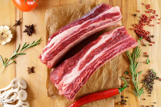 Raw cowboy steak on wooden background, prime rib eye on bone