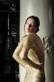 Glamour portrait of beautiful and sexy woman in gold dress