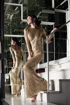 Full length portrait of young woman in beautiful dress on stairs