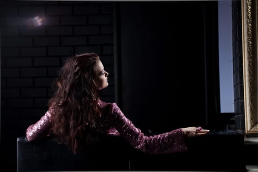 young brunette woman relax on black sofa in nightclub