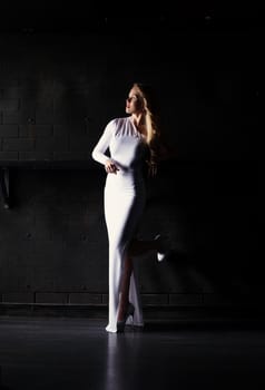 Elegant young woman posing in tight white dress, close-up