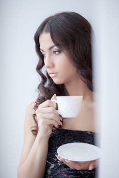 Portrait of pretty brunette woman drinking coffee