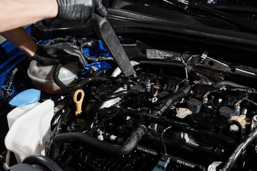 Process of drying car engine after washing with water and chemical detergent. Detailing cleaning motor from dust and dirt