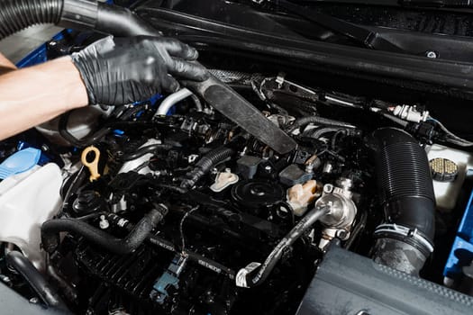 Process of drying car engine after washing with water and chemical detergent. Detailing cleaning motor from dust and dirt