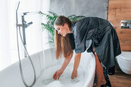 Beautiful young woman have free time at home in the bath.
