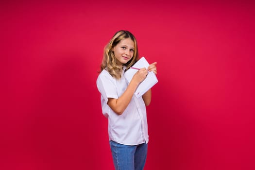 Child making notes. Kids dreams.Isolated on a red background. Education, Kid back to school.