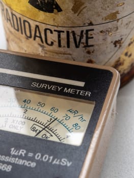 Hand-held radiation survey instrument detecting on radioactive material in the package. Ionizing radiation hazard symbol on package