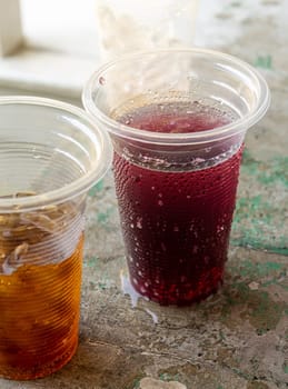 Soft drink and ice in the disposable plastic glasses