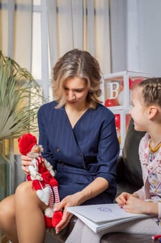 The girl psychologist plays a puppet character game with the child