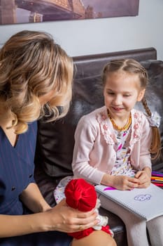 The girl psychologist plays a puppet character game with the child