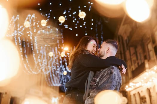 Happy multiracial couple together outdoors in the city celebrating New year.