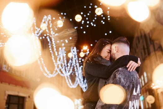Happy multiracial couple together outdoors in the city celebrating New year.