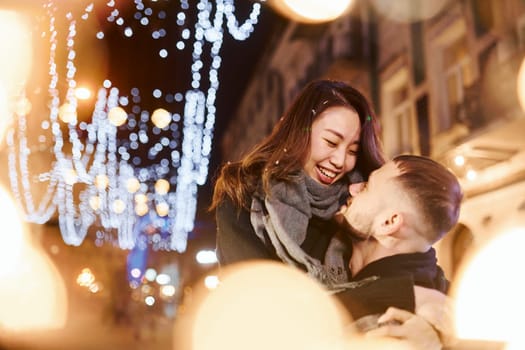 Embracing each other. Happy multiracial couple together outdoors in the city celebrating New year.