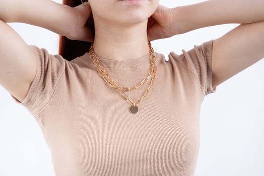Women wearing golden jewelry pendant necklace on white background