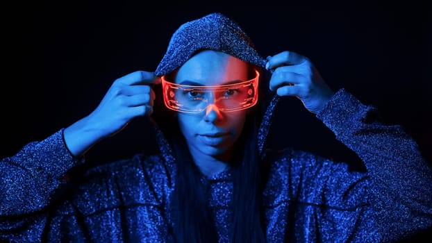 Portrait of young girl that is in eyeglasses in blue neon lighting.