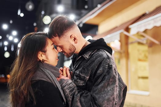 Embracing each other. Happy multiracial couple together outdoors in the city celebrating New year.