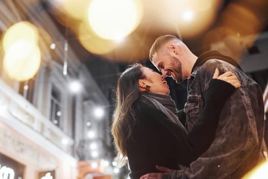 Embracing each other. Happy multiracial couple together outdoors in the city celebrating New year.