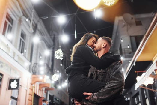 Embracing each other. Happy multiracial couple together outdoors in the city celebrating New year.