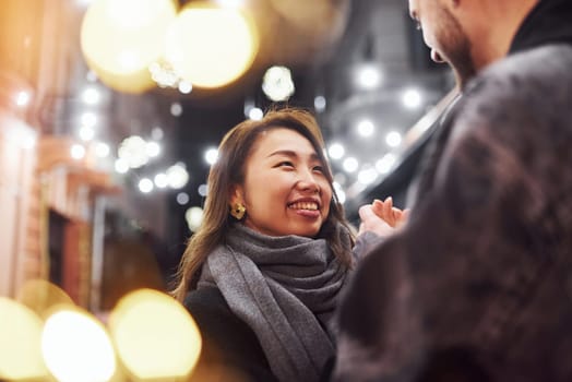 Happy multiracial couple together outdoors in the city celebrating New year.