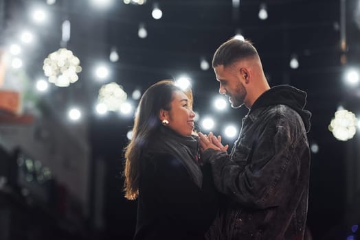 Happy multiracial couple together outdoors in the city celebrating New year.