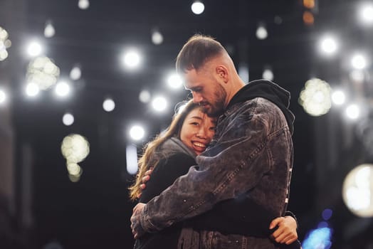Embracing each other. Happy multiracial couple together outdoors in the city celebrating New year.