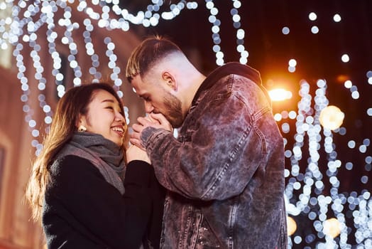 Happy multiracial couple together outdoors in the city celebrating New year.
