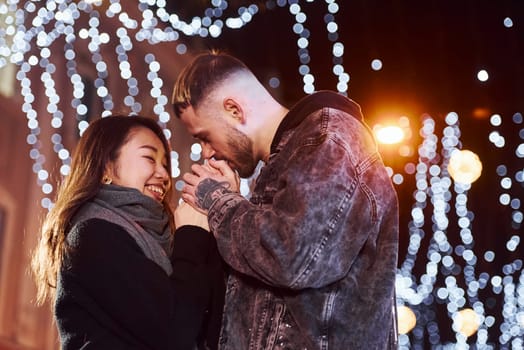 Happy multiracial couple together outdoors in the city celebrating New year.