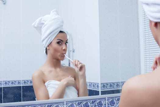 Portrait of young woman brushing her teeth