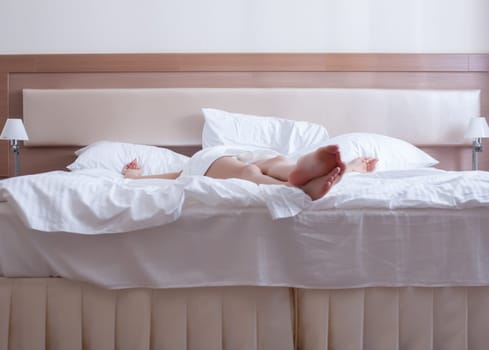 young woman relax on bed of hotel bedroom - legs only