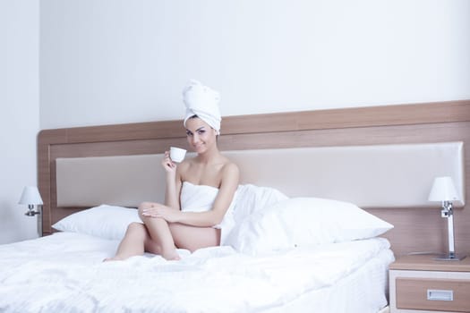 Beautiful brunette woman wearing only towels on her body and head