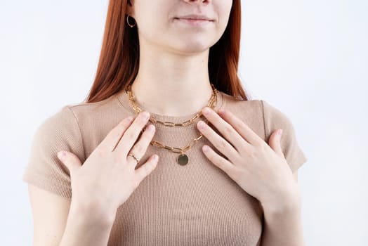 Women wearing golden jewelry pendant necklace on white background