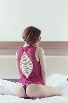 Portrait of beautiful woman sitting on bed