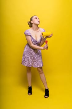 Young classic pin-up woman painting wall with a paint roller