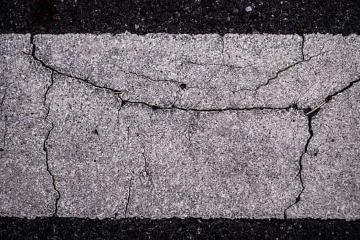 Close-up the cracked on the surface of Road Line painted