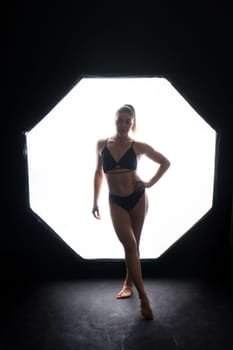 Silhouette of beautiful young woman wearing underwear in backlight