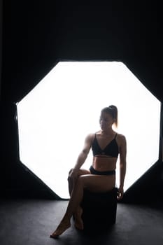 Silhouette of beautiful young woman wearing underwear in backlight