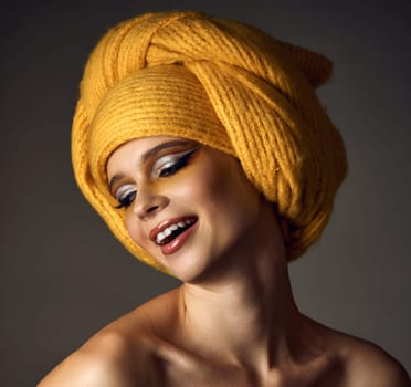 Beauty blonde model girl with fashionable creative make-up, bright eye line wear yellow turban. Creative eye makeup ideas.