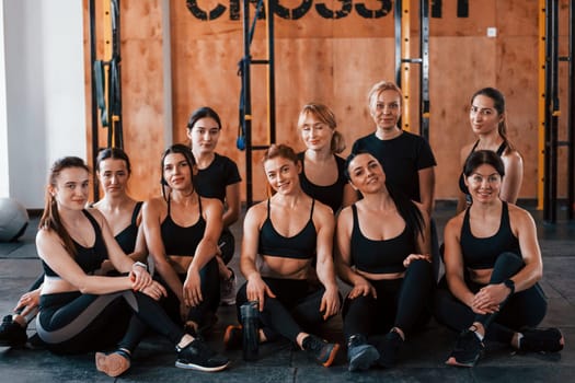 Posing for a camera. Group of young sportive people have crossfit day indoors in gym.