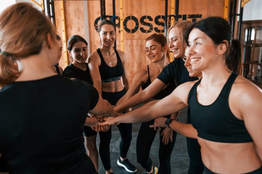 Taking a break. Group of young sportive people have crossfit day indoors in gym.
