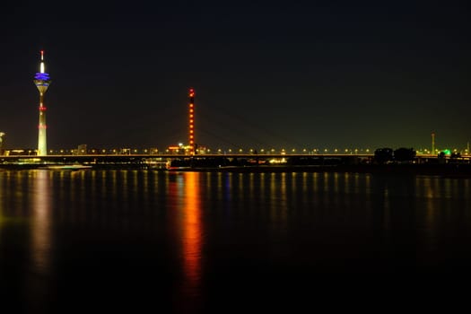 TV tower reflecting on Rhine River at night in Duesseldorf, Germany