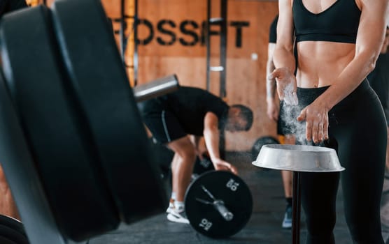 Group of young sportive people have crossfit day indoors in gym.