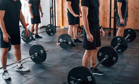 Group of young sportive people have crossfit day indoors in gym.