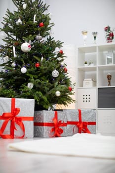 Cristmas gifts under the tree with Christams decorations. Christmas tree in living room.