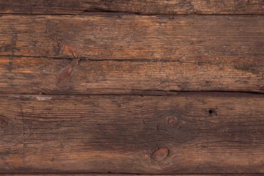 Several horizontally stacked old boards in clothes of brown color. Background of natural material slightly tattered.